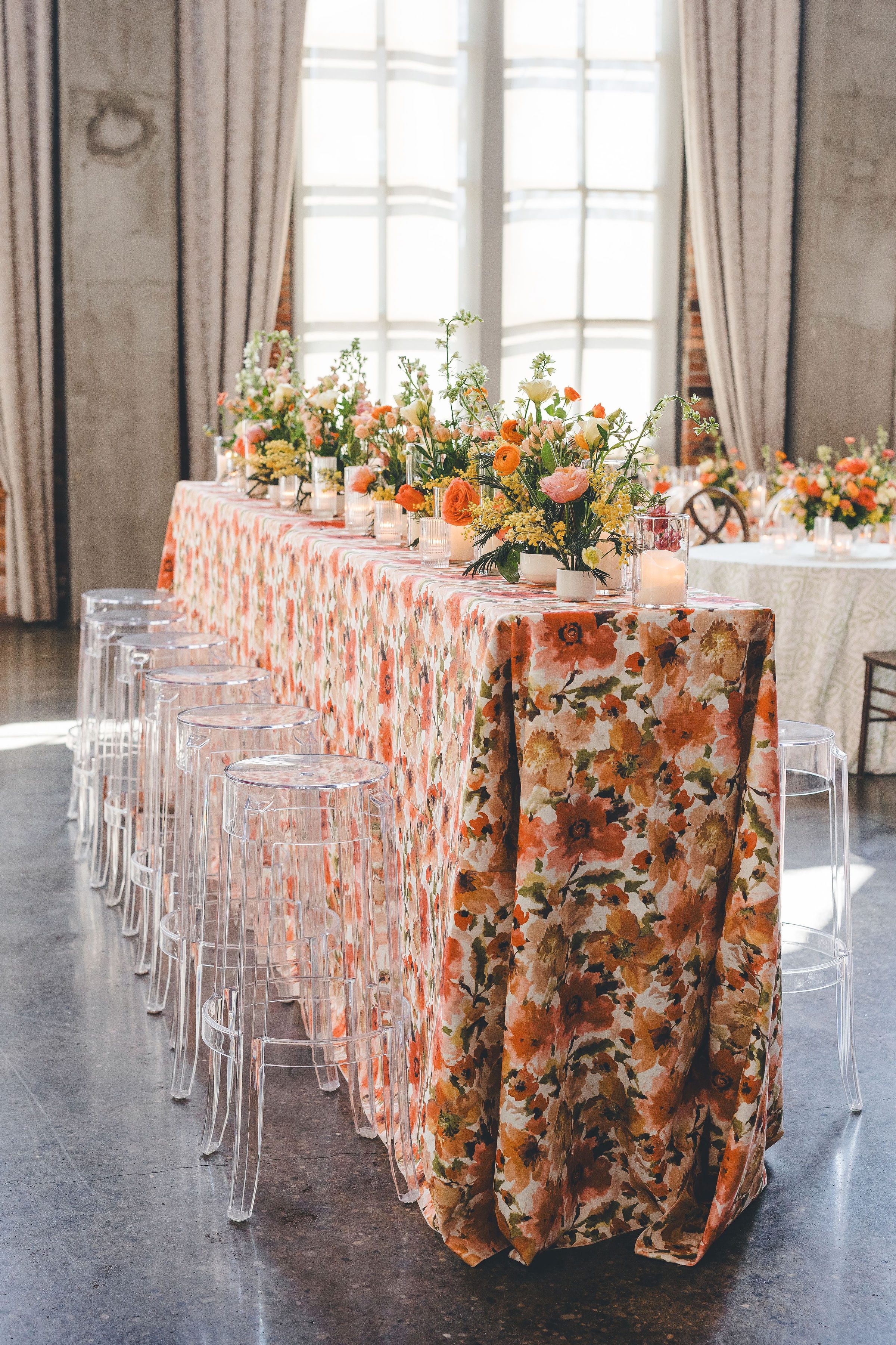 bar height table with colorful floral linen and floral centerpieces