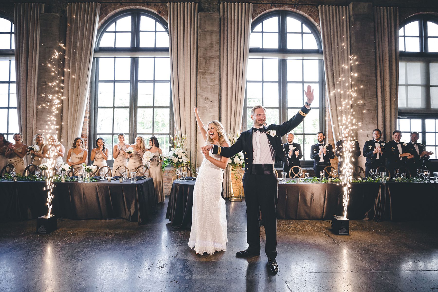 bride and groom dancing while wedding party cheers