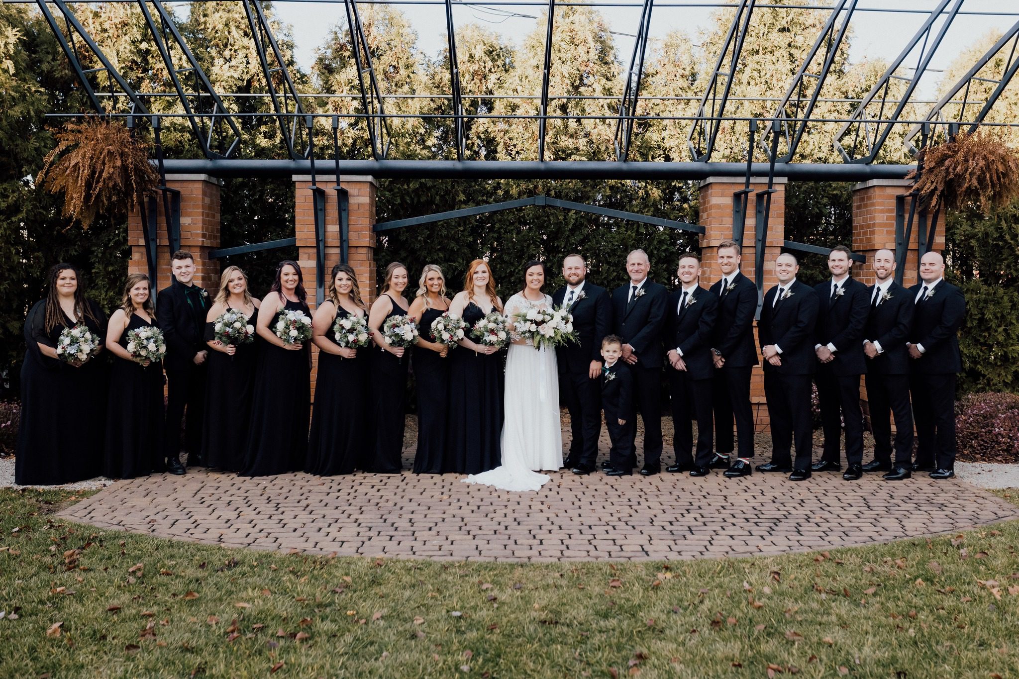 bride and groom with wedding party under pavilion