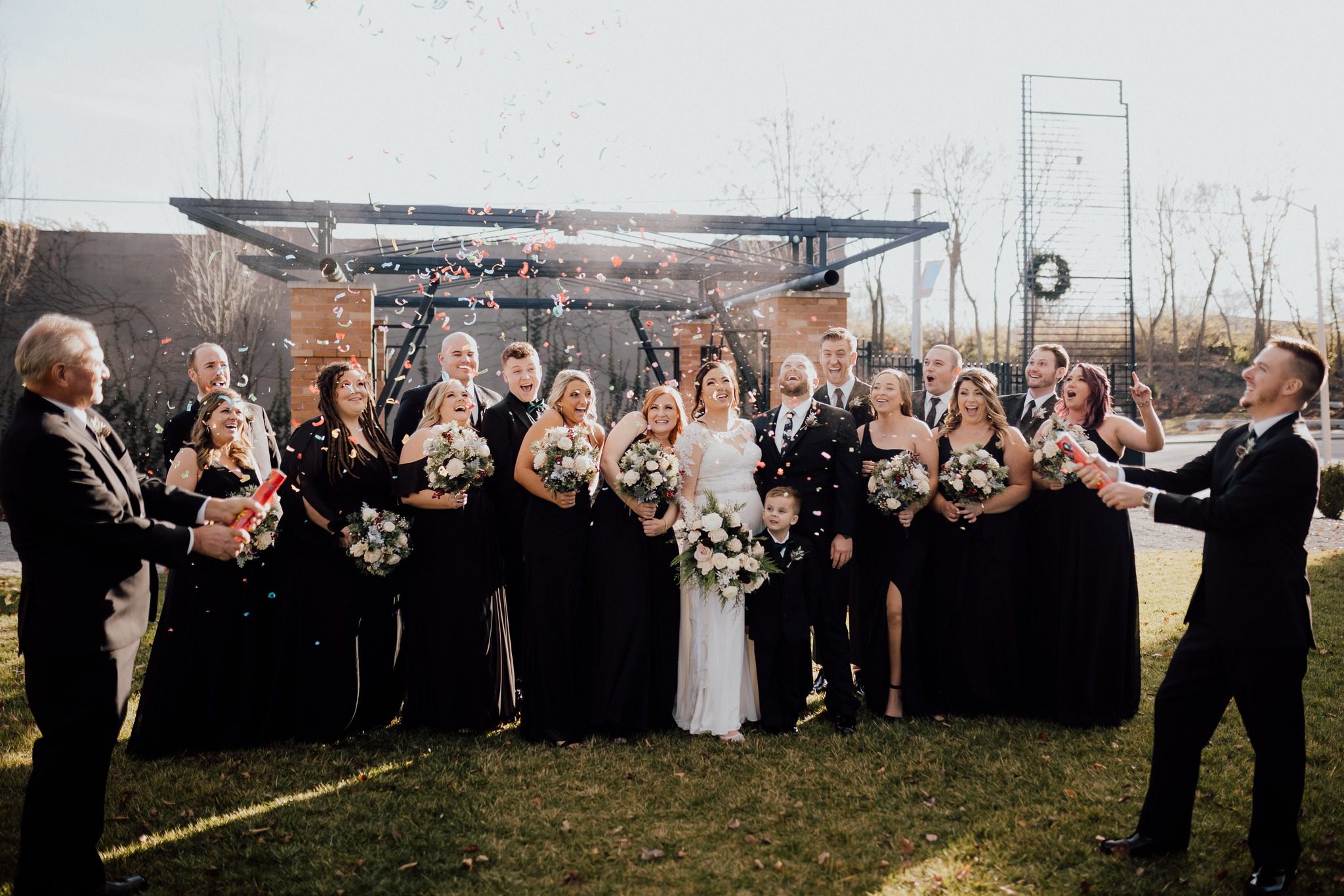 wedding party laughing as confetti falls