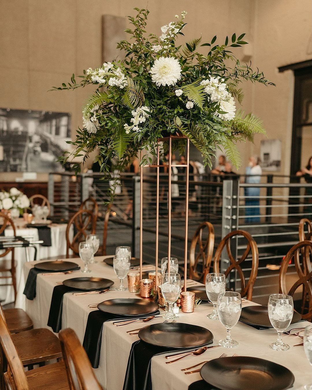 long wedding reception table with tall floral centerpiece