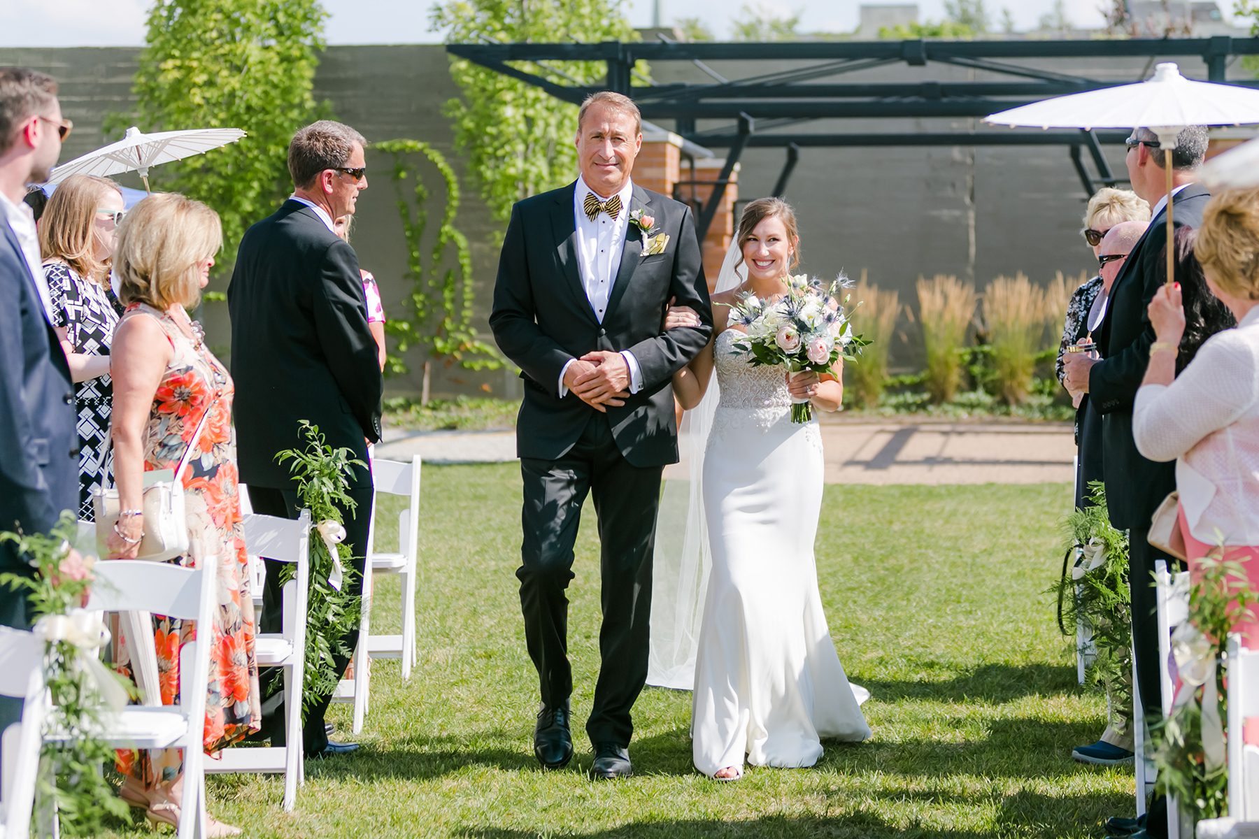 father walking bride down aisle in outdoor wedding ceremony