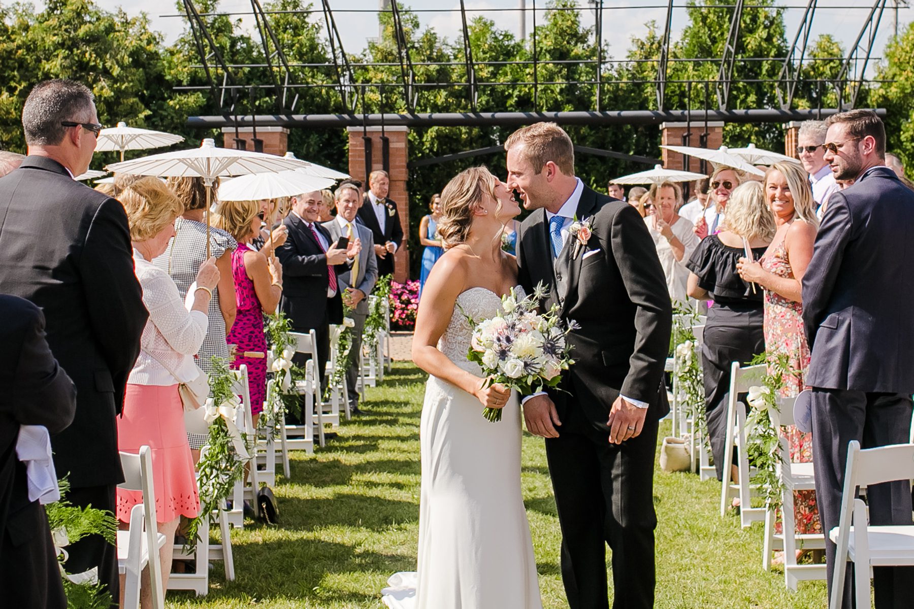 couple kissing at end of aisle