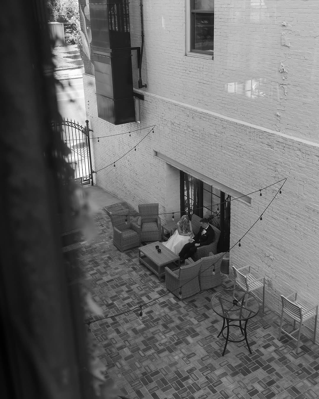 couple sitting on couch on wedding venue courtyard