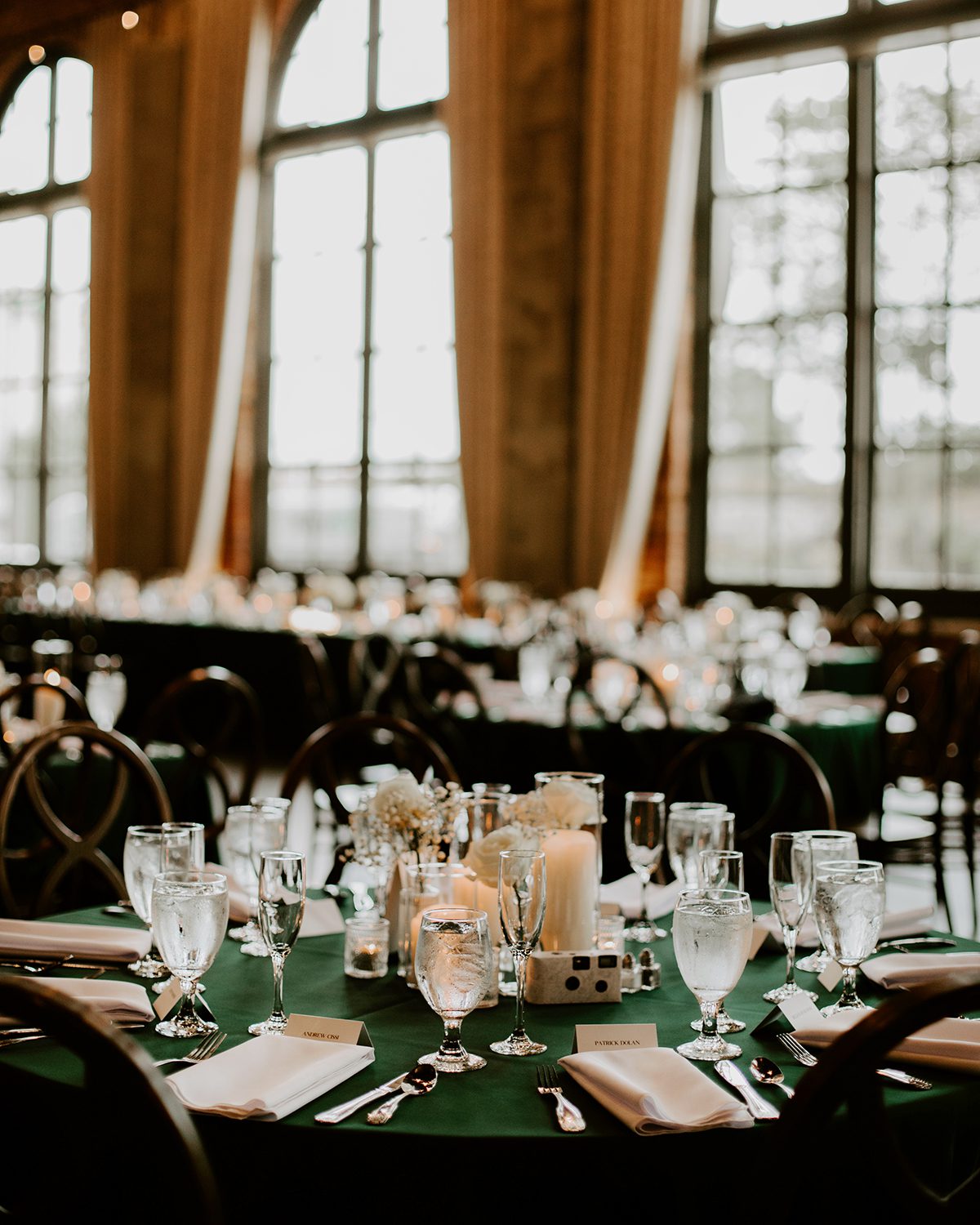 round wedding reception tables with green linens