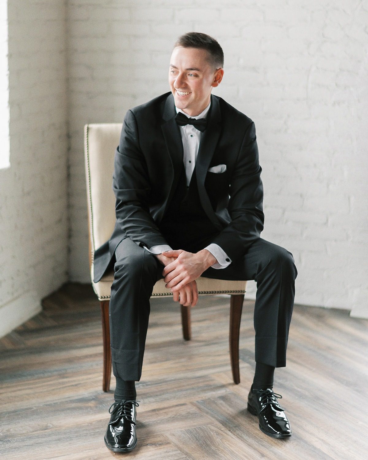 groom in bright white brick room