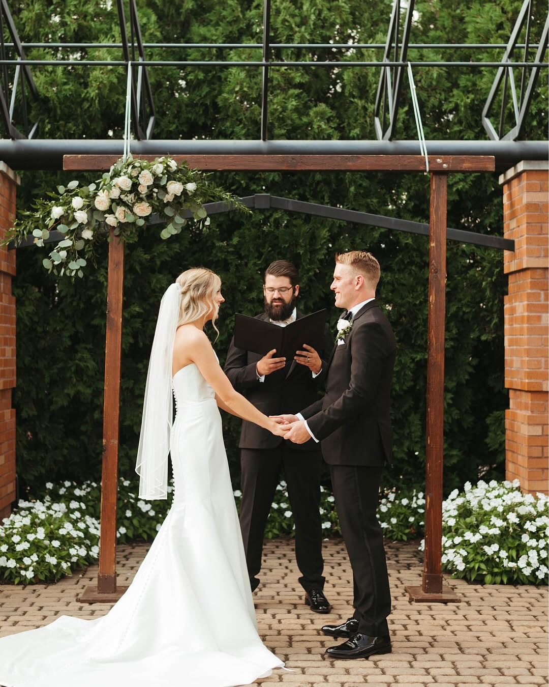 bride and groom holding hands while saying vows