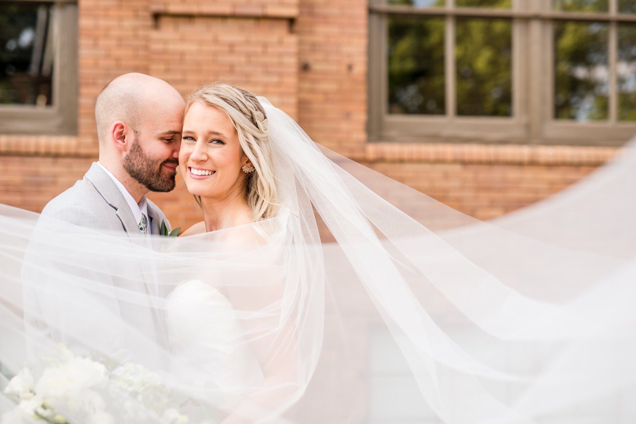 bride and groom surrounded by bride's veil